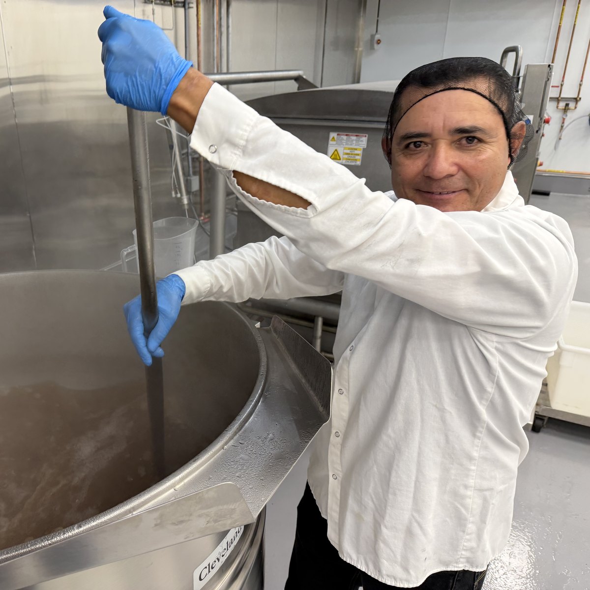 A Ladle & Leaf cook stirring a kettle of soup in the Oakland production kitchen