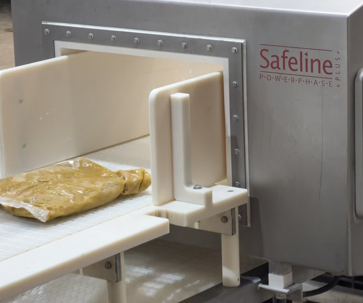 A sealed bulk bag of sauce passing through the inline metal detector